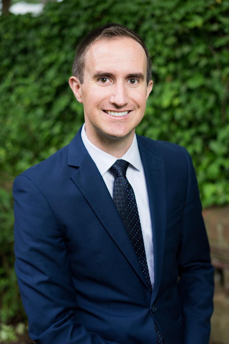 A person in a suit and tie
Description automatically generated with medium confidence